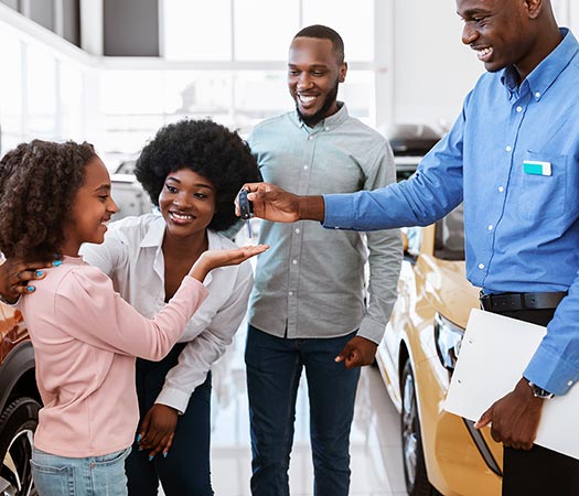 Car Salesman in Pasco Count, FL Handing Keys to New Owner's Child